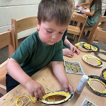 Plentyn yn addurno plat papur